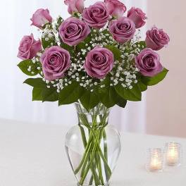 Lavender rose bouquet in a clear glass vase with baby's breath