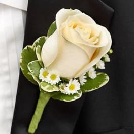 Cream rose boutonniere with small white daisies on a black jacket