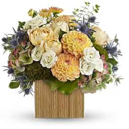Mixed bouquet of cream, yellow, and white flowers in a wooden box