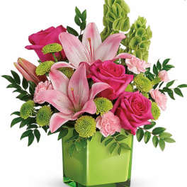 Pink lilies and roses in a green square vase