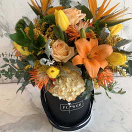Bouquet of orange and yellow flowers in a black hat box