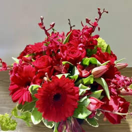 Red bouquet with roses, gerbera daisies, and orchids