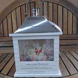 Decorative lantern with cardinal artwork and a metal top