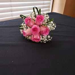 Pink rose bouquet with baby's breath on a dark table