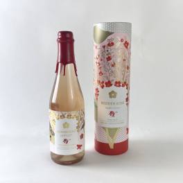 Two bottles of Hidden Rose hard cider, one in a decorative tube