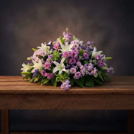 Low floral arrangement with white lilies and purple-pink blooms