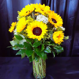 Bouquet of yellow sunflowers in a clear glass vase