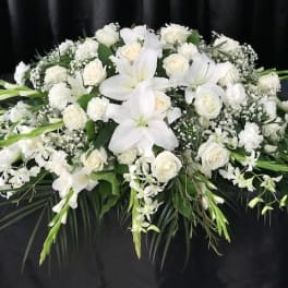 White floral casket spray with lilies and roses
