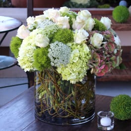 White roses and green hydrangeas in a glass vase