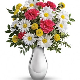 Bouquet of white daisies, pink carnations, and yellow button flowers in a silver vase