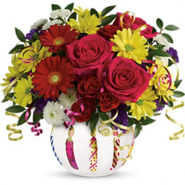 Mixed bouquet of roses and daisies in a white vase with curling ribbons