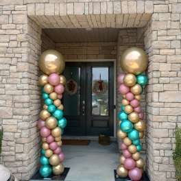 Pastel and metallic balloon columns framing a front door
