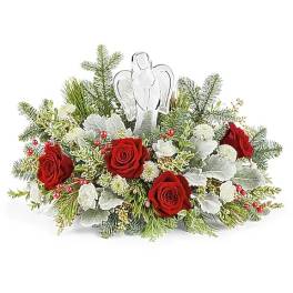 Red roses and white flowers arranged with an angel figurine