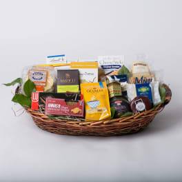 Gift basket with assorted packaged snacks and chocolates in a wicker tray