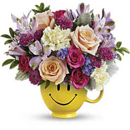 Colorful mixed bouquet in a yellow smiley-face mug