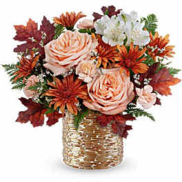 Autumn bouquet of peach roses and orange flowers in a gold basket vase
