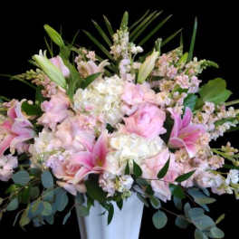 Pink lilies and pale roses in a white vase