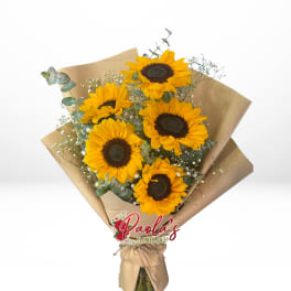 Bouquet of sunflowers wrapped in brown paper with a ribbon