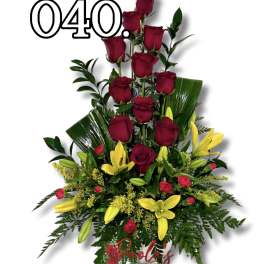 Tall arrangement of red roses and yellow lilies in a white vase