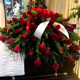Large casket spray of red roses with white ribbons