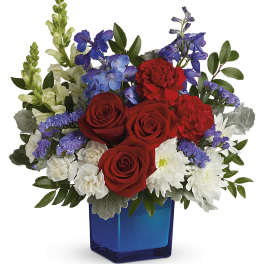 Red roses, white daisies, and purple flowers in a blue vase