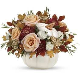 Autumn floral arrangement with peach roses in a white pumpkin vase