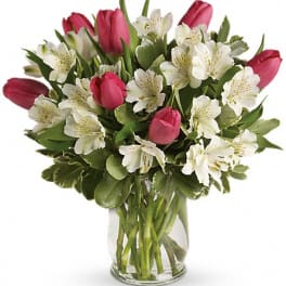 Pink tulips and white alstroemeria in a clear glass vase