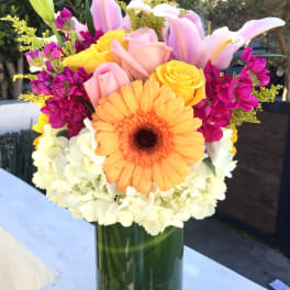 Colorful bouquet in a glass vase with lilies, roses, gerbera daisy, and hydrangeas