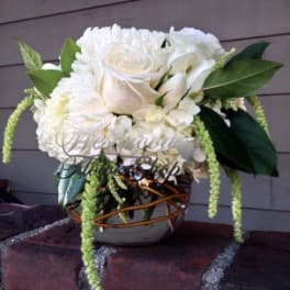 White rose and chrysanthemum arrangement in a woven vase