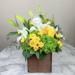 Yellow roses and white lilies in a wooden box arrangement
