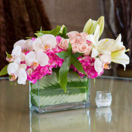 Pink and white floral arrangement in a rectangular glass vase