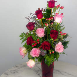 Red and pink roses arranged in a tall vase