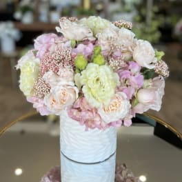Pastel bouquet of roses and hydrangeas in a white vase