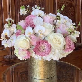 Pink and white floral arrangement in a gold vase