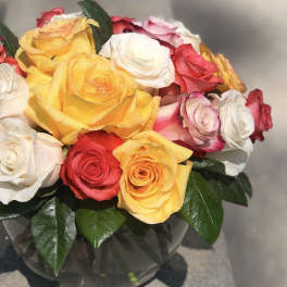 Bouquet of multicolored roses in a clear glass vase
