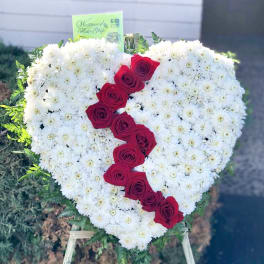 Heart-shaped floral tribute with white daisies and red roses