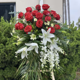 Standing floral spray with red roses, white lilies, and white orchids