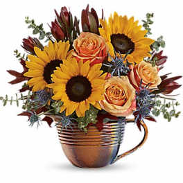 Sunflowers and peach roses arranged in a copper mug