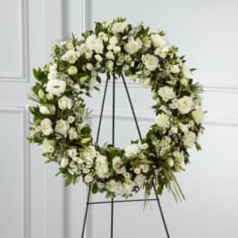 White floral wreath on a black stand