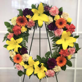 Heart-shaped floral wreath with yellow lilies, gerberas, and carnations