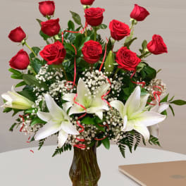 Red roses and white lilies arranged in a glass vase