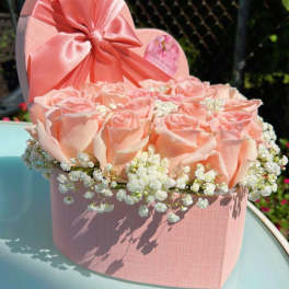 Pink roses in a heart-shaped box with baby's breath