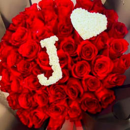 Heart-shaped bouquet of red roses with white floral letters