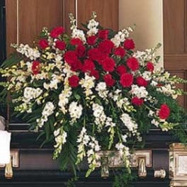 Large funeral spray of red and white flowers on a casket