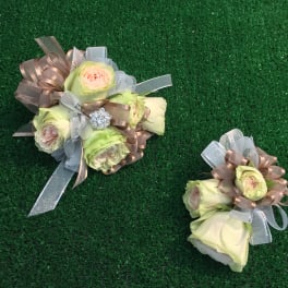 Two small rose bouquets with ribbon bows on green turf
