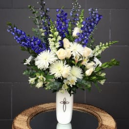 Tall white vase arrangement with blue and white flowers