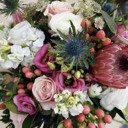 Mixed bouquet with pink and white flowers and a blue thistle bloom