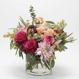 Mixed pink and peach bouquet in a clear glass vase