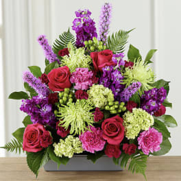 Bright pink and purple floral arrangement in a rectangular vase