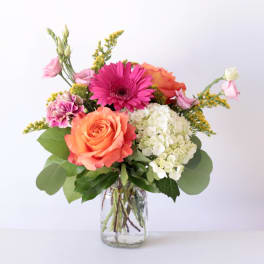 Mixed bouquet with roses, gerbera daisy, hydrangea, and carnations in a glass vase